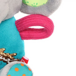Close-up of a colorful dog toy with a pink rattle and teal body on a white background