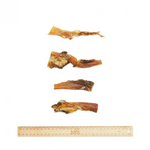 Dog treats arranged on a white background with a ruler for scale.