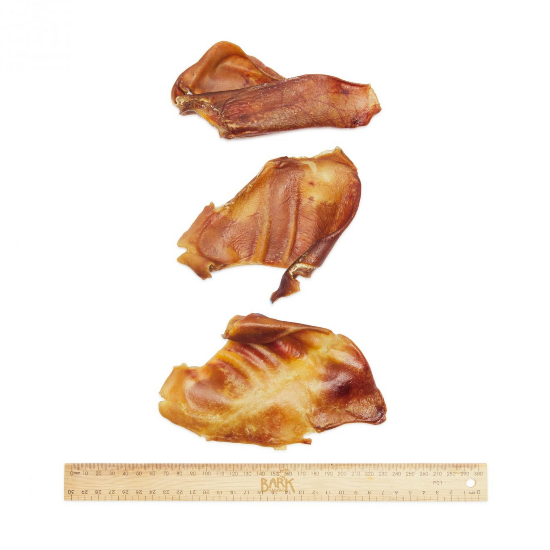 Three pieces of rawhide with a ruler for scale on a white background