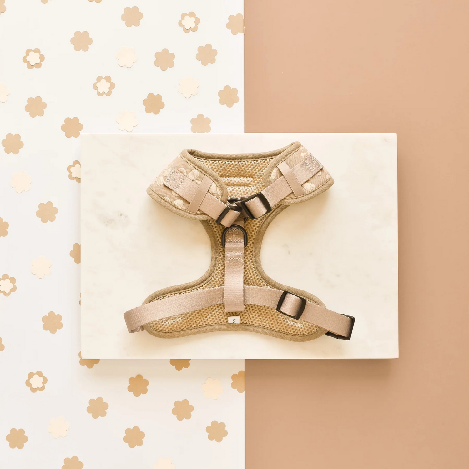 Beige dog harness on a white card with a beige background