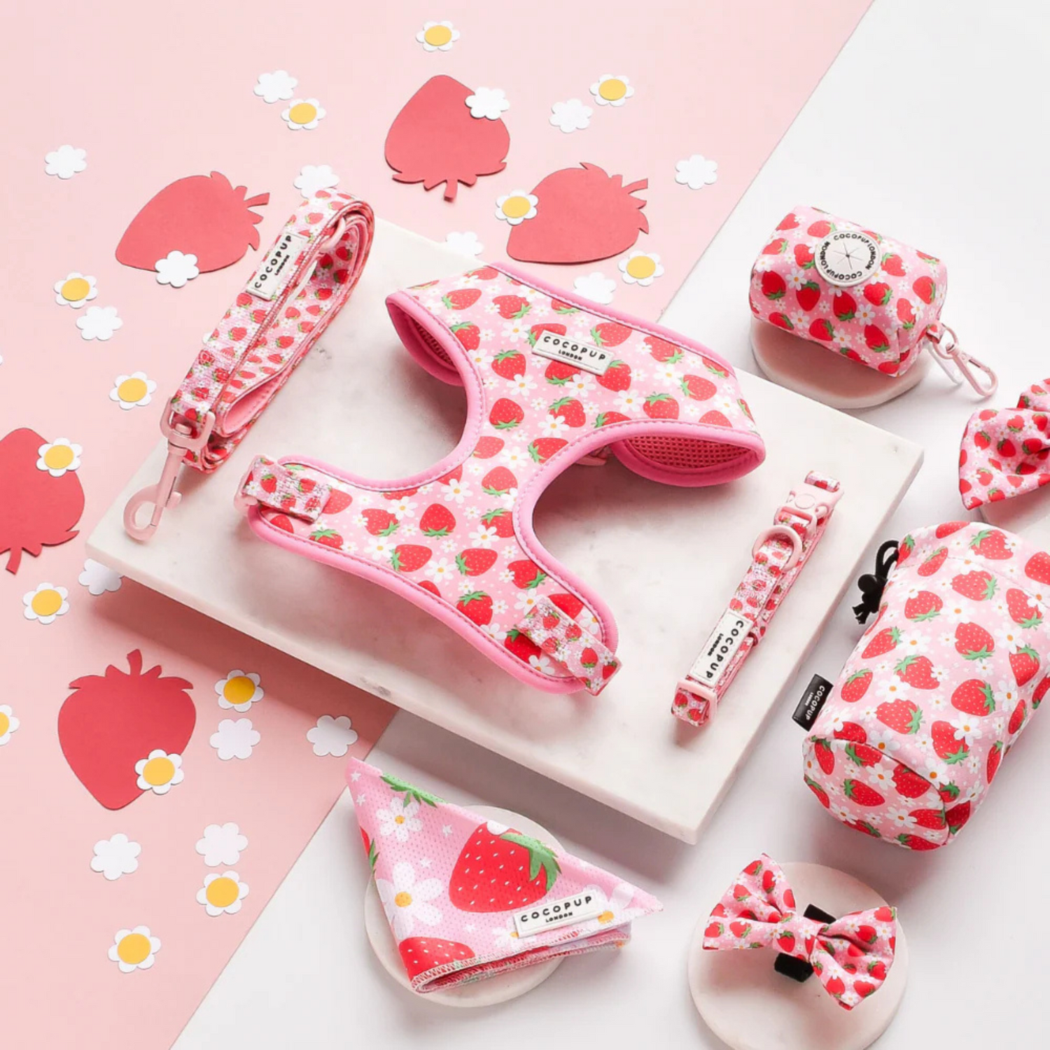 Set of pink pet accessories with strawberry pattern on a pink background