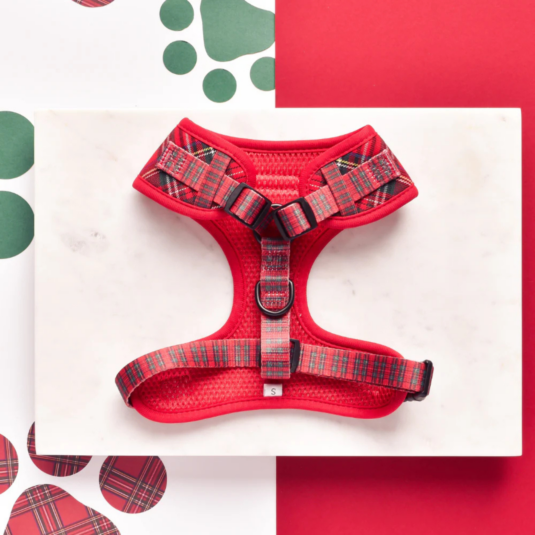 Red plaid dog harness on a white background with red and green accents.