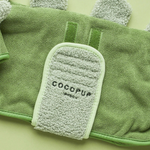 Green towel with a textured pad featuring 'Cocopup' branding on a green background.