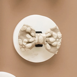 Decorative dog bow tie with floral pattern on a beige background