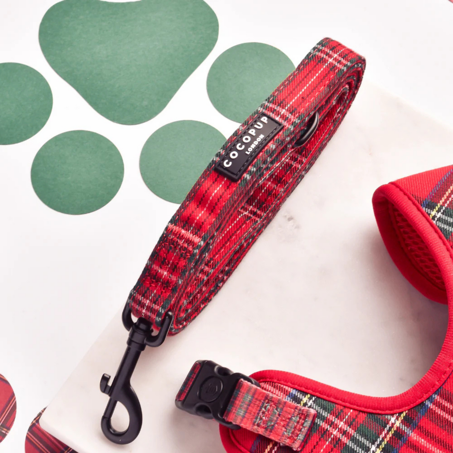 Red plaid dog collar and leash on a white background with green heart shapes.