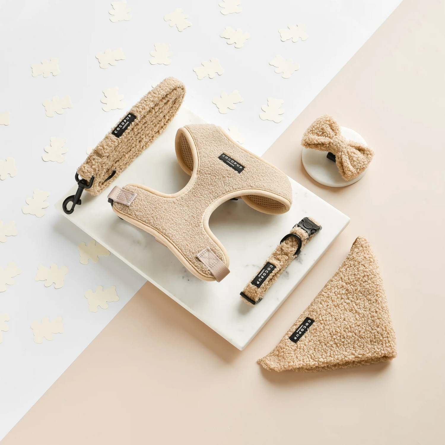 Set of beige pet accessories including a harness, leash, and collar on a light background.