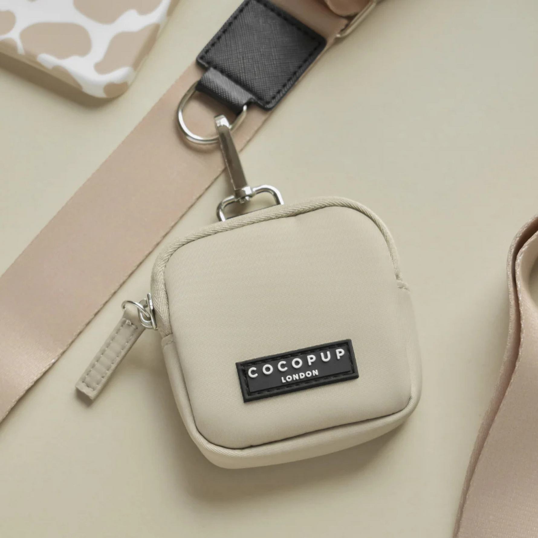 Beige pouch with COCOPUP London label on a beige background