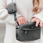 Person holding a gray bag with COCOPUP branding, wearing a white sweater.