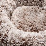 Close-up of a beige, fluffy pet bed with a soft texture.