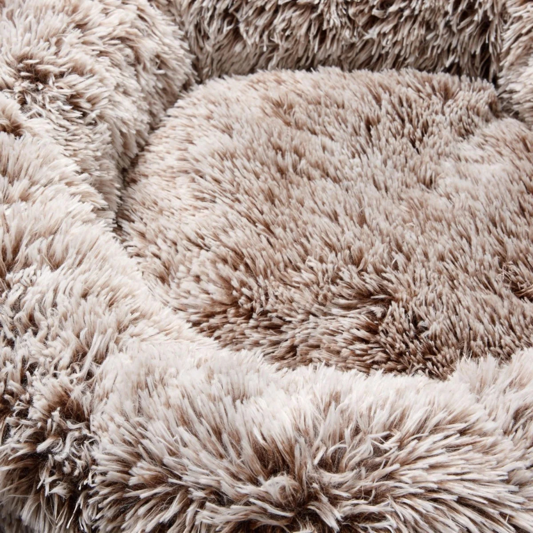 Close-up of a beige, fluffy pet bed with a soft texture.