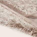 Close-up of a fluffy beige blanket with soft texture