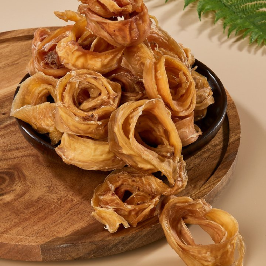 Dried flower-shaped snacks on a wooden board with a beige background