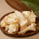 Dried white mushrooms on a wooden plate with a natural background