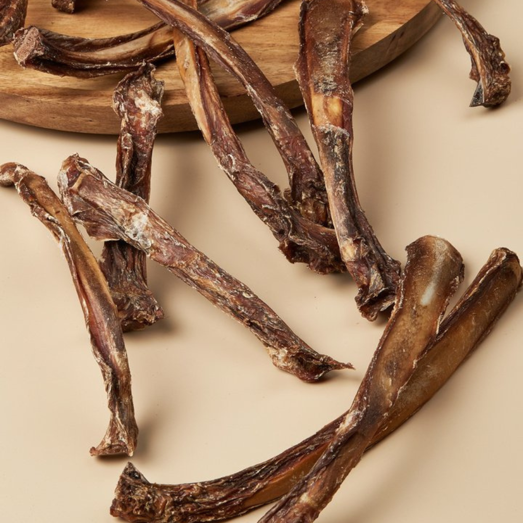 Dried animal bones on a wooden board with a beige background