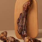 Dried meat on a wooden cutting board with a beige background